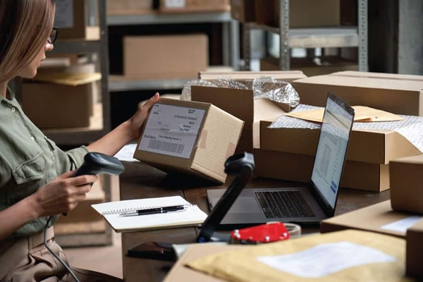 Business owner packing and shipping out an order from a loyal customer after learning how to create a memorable e-commerce customer experience 