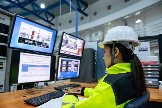 A 4PL logistics worker overseeing the entire logistics process from multiple computer screens