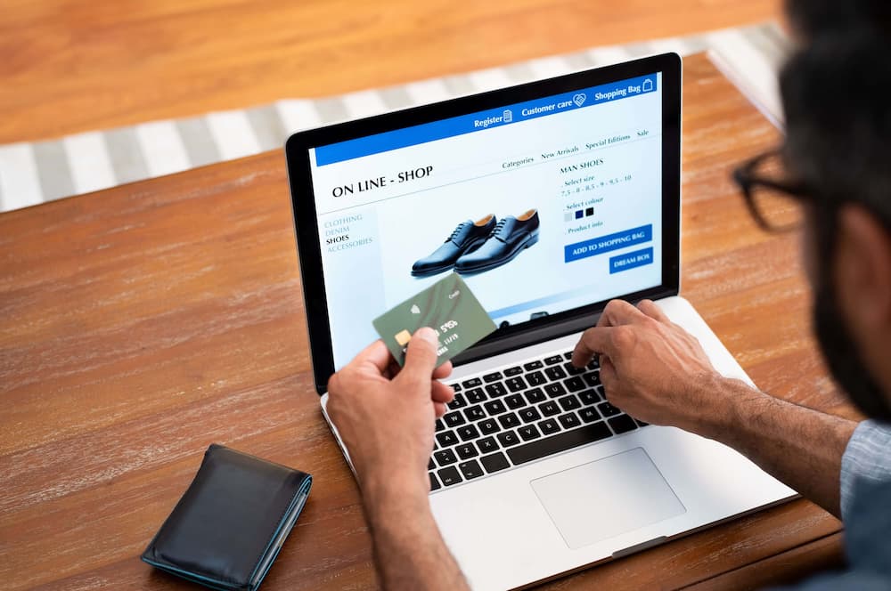 a person holding his card while shopping online