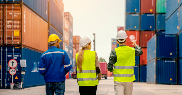 three people walking outside near the shipping docks