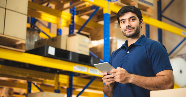 a working man holding a tablet inside the warehouse